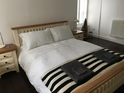 a bedroom with a large bed with two towels on it at The Old Vicarage in Looe