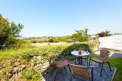 a table and chairs sitting on a stone patio at Wrens Nook in St. Agnes