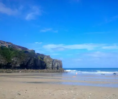 a beach with the ocean and a cliff at Wrens Nook in St. Agnes