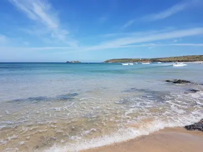 a beach with some boats in the water at The Lodge, Polgooth in St Austell