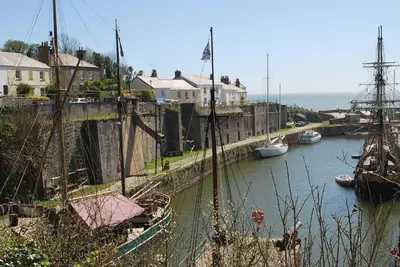 a group of boats are docked in a river at The Lodge, Polgooth in St Austell
