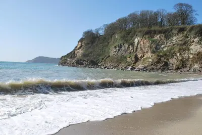 a beach with the ocean and a rocky coastline at The Lodge, Polgooth in St Austell