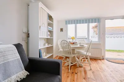 a living room with a table and chairs and a window at Gwithian, Sea Dream Beach Chalet in Gwithian