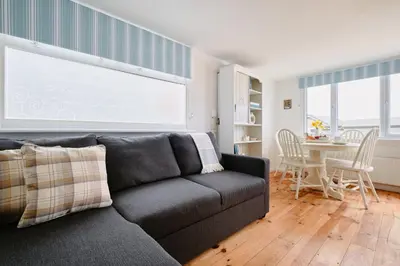 a living room with a couch and a table at Gwithian, Sea Dream Beach Chalet in Gwithian