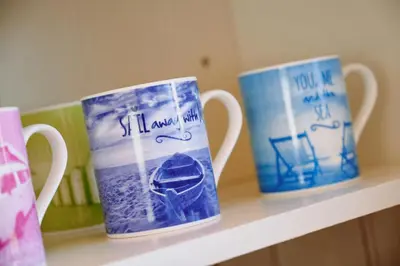 three coffee cups sitting on a shelf at Gwithian, Sea Dream Beach Chalet in Gwithian