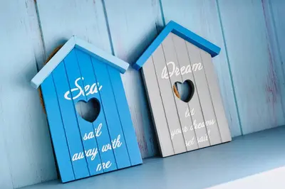 three blue houses with hearts on them sitting on a shelf at Gwithian, Sea Dream Beach Chalet in Gwithian