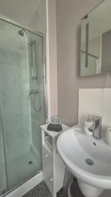a white bathroom with a sink and a shower at Tregarthen - Adult Only in Newquay