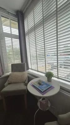 a chair and a table in a room with windows at Tregarthen - Adult Only in Newquay