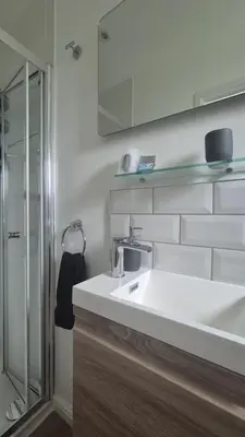 a bathroom with a white sink and a shower at Tregarthen - Adult Only in Newquay