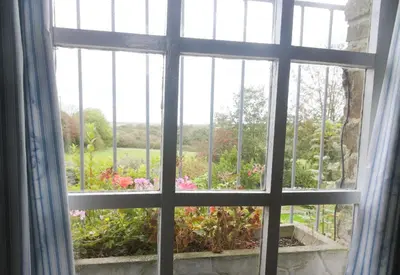 an open window with a view of a garden at Old Newham Farm in Camelford