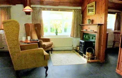 a living room with a couch and a fireplace at Old Newham Farm in Camelford