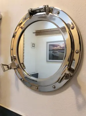 a mirror with a metal frame on a wall at Re-imagined Stone Barns in the Country Near the Coast in Padstow