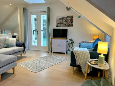 a living room with a couch and a tv at Fowey River Views in Fowey