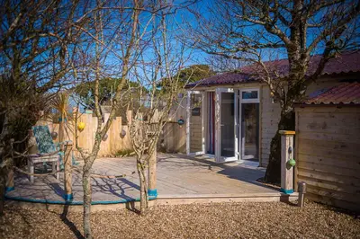 a house with a wooden porch with a chair on a wooden deck at Driftwood in Bude
