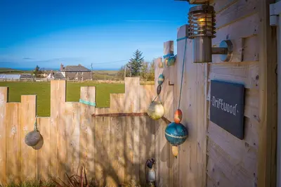 a wooden fence with some decorations on it at Driftwood in Bude