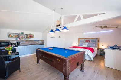 a room with a pool table and a bed at Driftwood in Bude