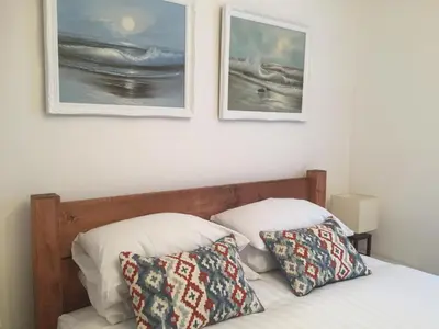 a bed with two pillows and two pictures on the wall at SeaQuest 5 in Newquay