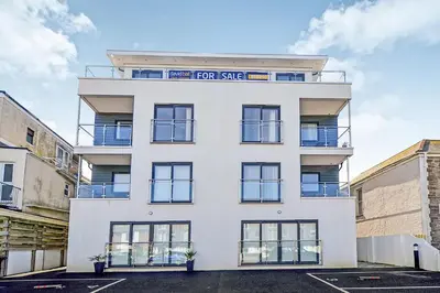 a white building with a for sale sign on it at SeaQuest 5 in Newquay