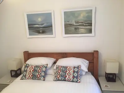 a bedroom with a bed with two pictures on the wall at SeaQuest 5 in Newquay