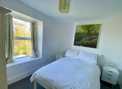 a bedroom with a white bed and a window at Coast Accommodation in St Ives