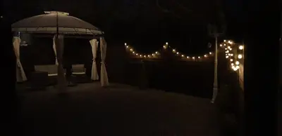 a gazebo with lights and a chair in the dark at C28 Angels retreat in Par