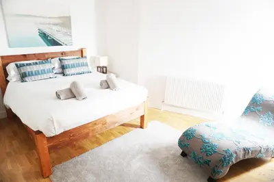 a bedroom with a bed and a chair at SeaQuest 8 in Newquay