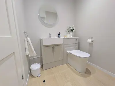 a bathroom with a sink and a toilet and a mirror at Porthpean Apartment in Charlestown