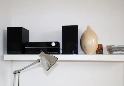 a white shelf with two speakers and a lamp at Porthpean Apartment in Charlestown