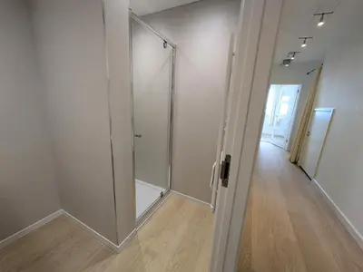 a walk in shower in a room with a glass door at Porthpean Apartment in Charlestown