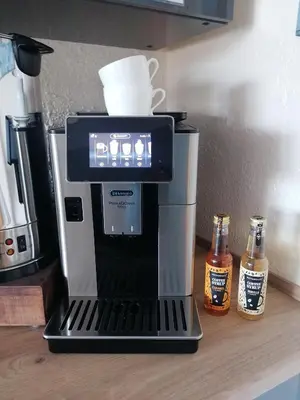 a coffee maker on a counter with two bottles of beer at Pensalda Guest House in Newquay
