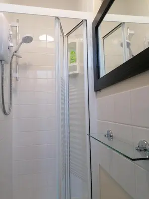 a bathroom with a shower and a mirror at Pensalda Guest House in Newquay