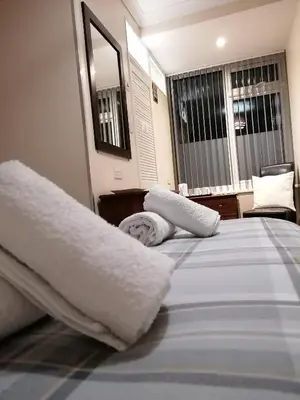a bedroom with a bed with white sheets and pillows at Pensalda Guest House in Newquay