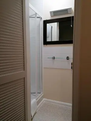 a bathroom with a walk in shower with a mirror at Pensalda Guest House in Newquay