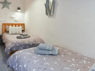 a bedroom with two beds with towels on them at Willow - 31287 in Porthtowan