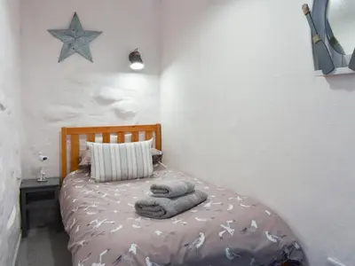 a bedroom with a bed with towels on it at Willow - 31287 in Porthtowan
