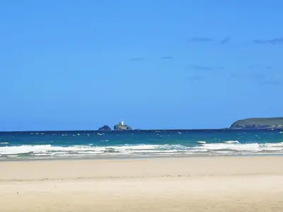 a person standing on a beach near the ocean at Willow - 31287 in Porthtowan
