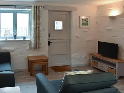 a living room with a couch and a television at Willow - 31287 in Porthtowan