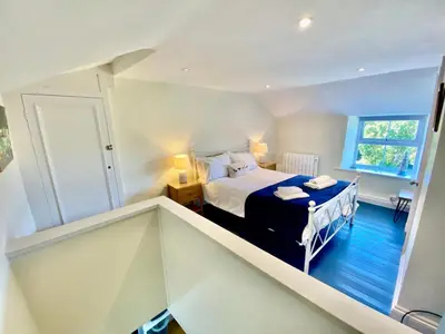 a small bedroom with a bed and a window at Froglets in Tregoney