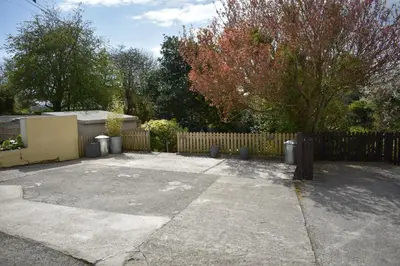 a parking lot in front of a wooden fence at Froglets in Tregoney