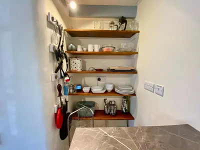 a kitchen with a shelf with plates and utensils at Froglets in Tregoney