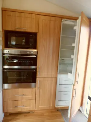 a kitchen with wooden cabinets and an oven at Peace and quiet in countryside location near Perranporth in Perranzabuloe
