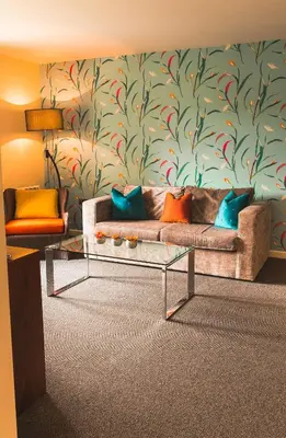 a living room with a couch and a wall at Lanhydrock Hotel & Golf Club in Bodmin