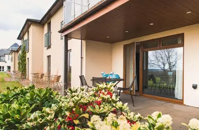 a house with a patio with a sliding glass door at Lanhydrock Hotel & Golf Club in Bodmin