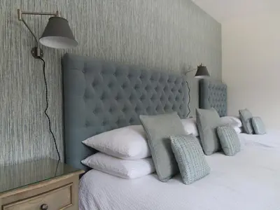 a bedroom with a bed with a blue headboard and pillows at Falmouth Bay in Falmouth