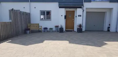a white house with a bench and potted plants at Primrose House in St Ives
