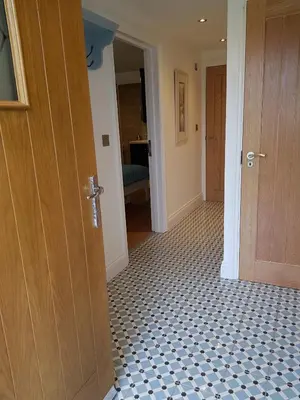 a hallway with a door and a tiled floor at Primrose House in St Ives