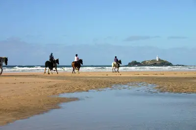 a group of people riding horses on the beach at Primrose House in St Ives
