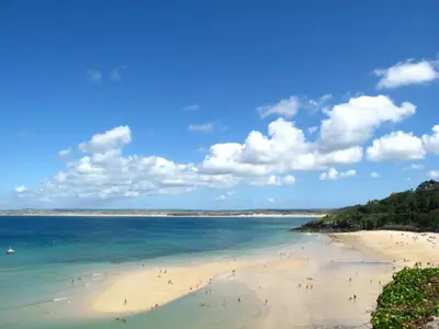 a beach with a bunch of people in the water at Primrose House in St Ives