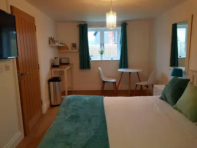 a bedroom with a bed and a window and a table at Primrose House in St Ives