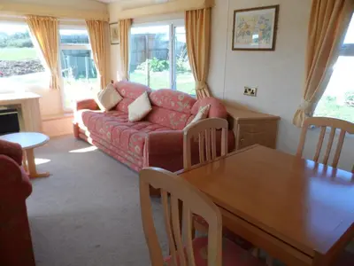 a living room with a red couch and a table at Luxury Mobile Home near Perranporth situated on a quiet farm in Truro